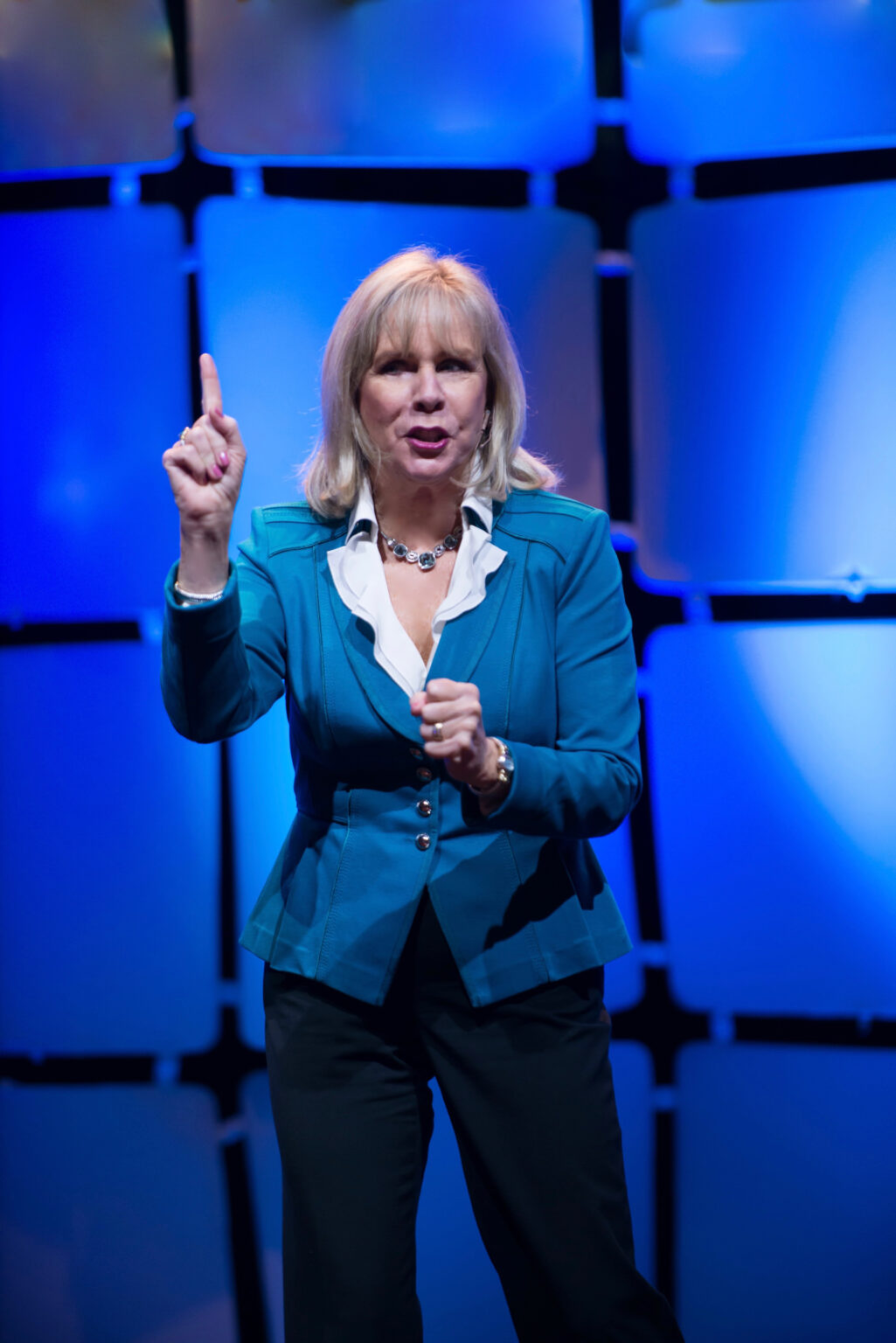 Motivational Speaker Linda Larsen on Stage Making a Point High Resolution